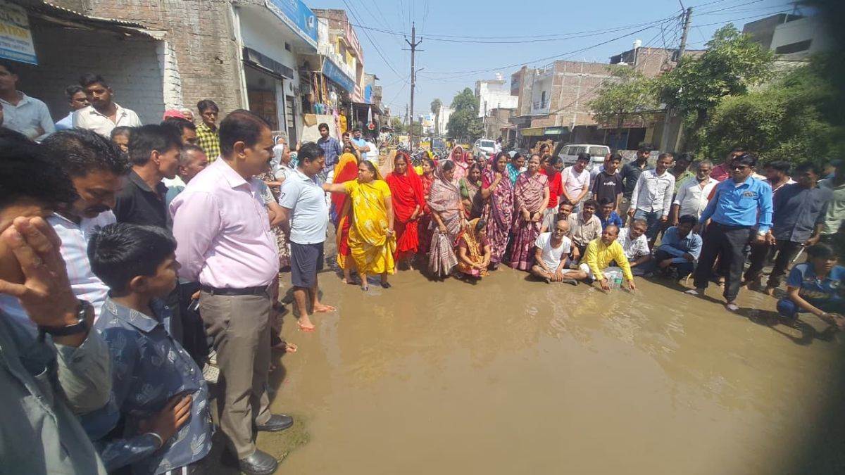उज्जैन में अपनी ही सरकार के खिलाफ सड़क पर बहते गंदे पानी के बीच धरने पर बैठे...