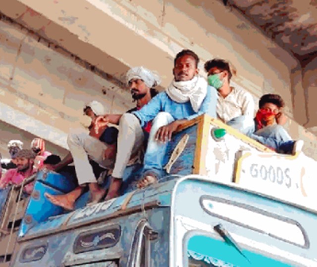 ट्रक के ऊपर मजदूर