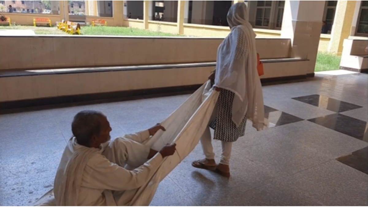 Gwalior: अस्पताल में स्ट्रेचर नहीं मिला तो मरीज को चादर पर बैठाकर खींचना पड़ा