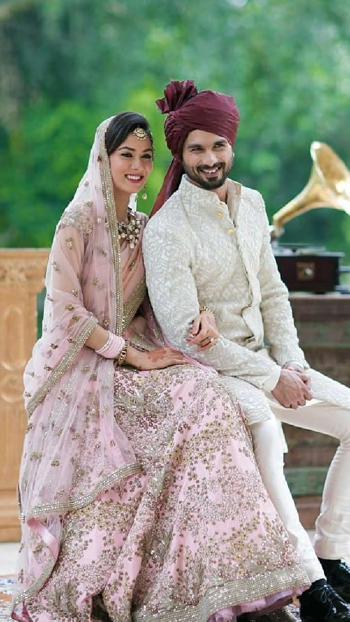 Photo of A bride in a pretty pink lehenga and groom in white sherwani.